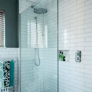 white tiled shower area with glass partition