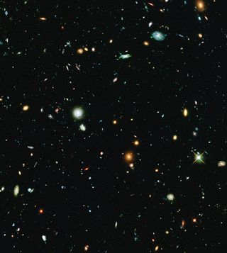 This long-exposure Hubble Space Telescope image of massive galaxy cluster Abell 2744 is the deepest ever made of any cluster of galaxies. It shows some of the faintest and youngest galaxies ever detected in space. Abell 2744, located in the constellation Sculptor, appears in the foreground of this image. It contains several hundred galaxies as they looked 3.5 billion years ago. The immense gravity in Abell 2744 acts as a gravitational lens to warp space and brighten and magnify images of nearly 3,000 distant background galaxies.
