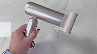 A hand holding the Dreame Pocket Hair Dryer