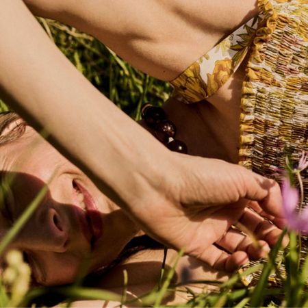 Young woman in a Liberty yellow dress in a field