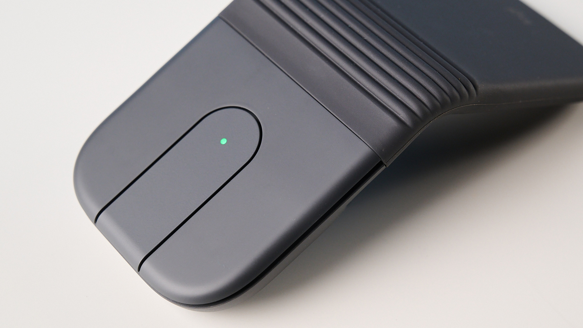Logitech Mobi Fold mouse in graphite photographed in front of a blue background