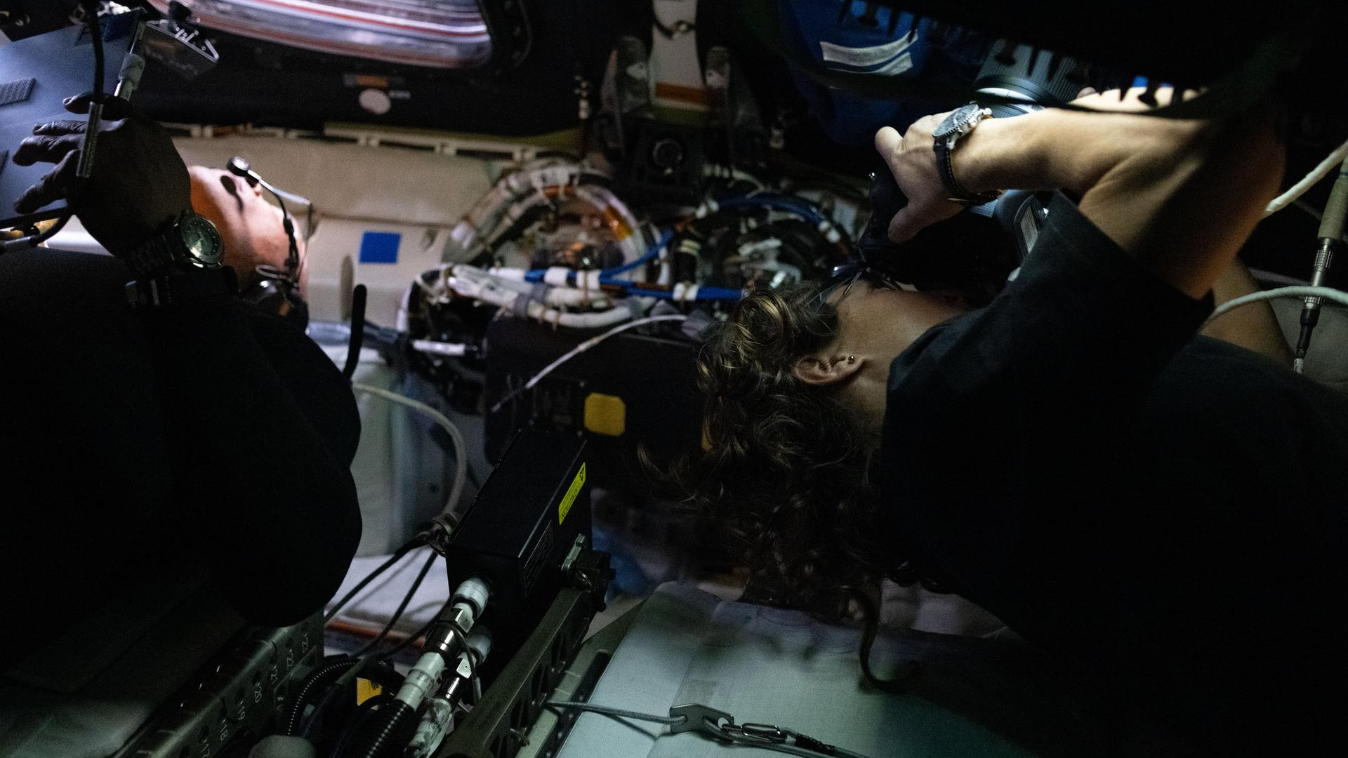 Victor Glover (left) and Christina Koch (right) take photos during Artemis II.