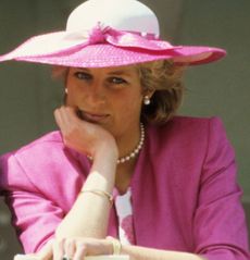 Princess Diana wearing a pink blazer and white hat resting her chin on her hand at the 1987 Epsom Derby 