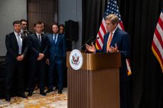 John Kerry speaks at a lectern in front of U.S. flags 