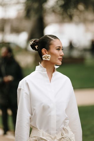 woman in a white shirt and bun