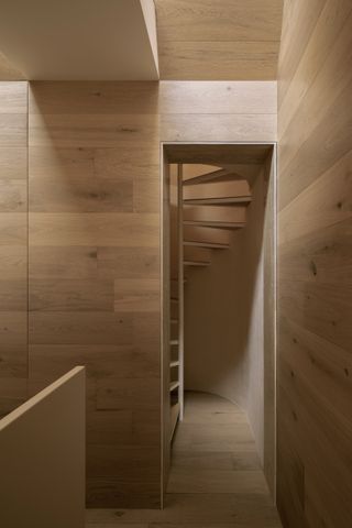 The compact spiral staircase leads up to the bedroom