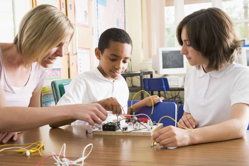 Students and teacher in class with electronic project.