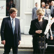 Princess Diana wearing a black blazer walking next to bodyguard Ken Wharfe