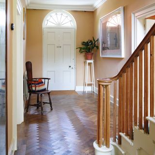 hallway with white front door and wooden staircase