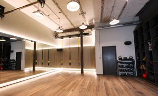 Room includes cantilevered metal I-beams mounting retractable training equipment