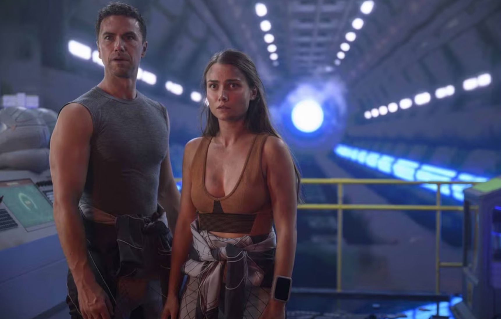 a man and a woman standing together in a huge spaceship