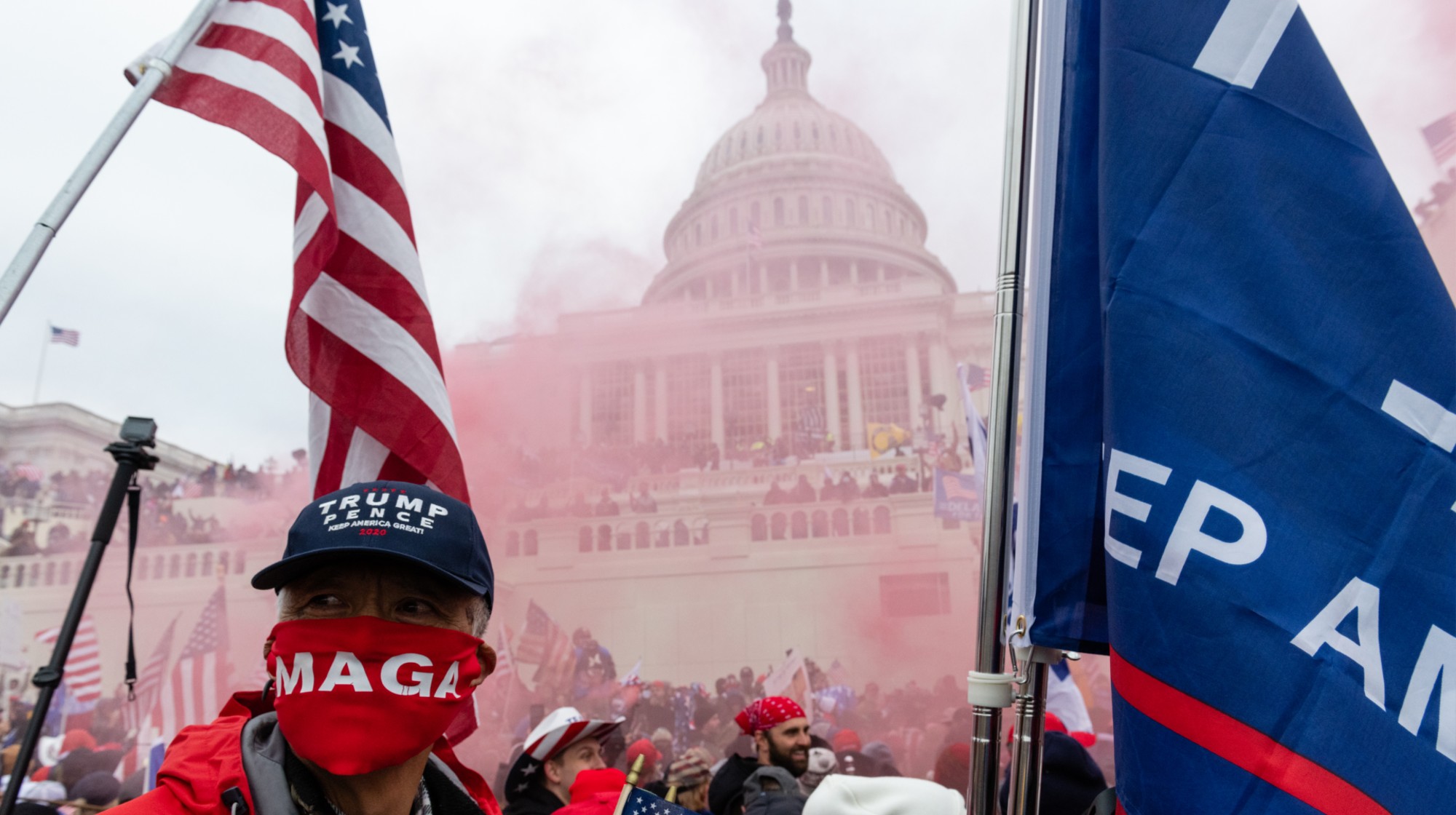 A protester unleashes a smoke grenade in front of the U.S. Capitol building during a protest in Washington, D.C., U.S., on Wednesday, Jan. 6, 2021. The U.S. Capitol was placed under lockdown and Vice President Mike Pence left the floor of Congress as hundreds of protesters swarmed past barricades surrounding the building where lawmakers were debating Joe Biden's victory in the Electoral College. Photographer: Eric Lee/Bloomberg via Getty Images