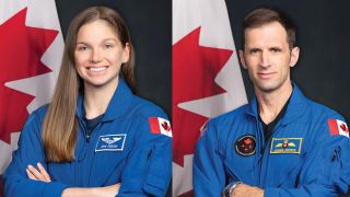 two astronauts in blue flight suits pose in front of the Canadian flag