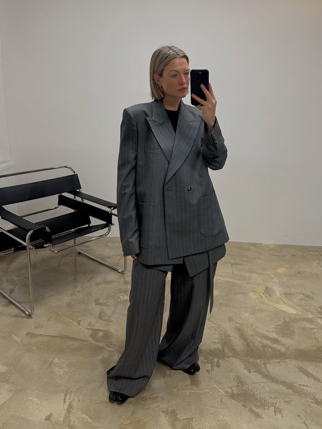 Influencer Alexis Foreman wearing a pinstripe suit, wide-leg trousers and ballet flats.