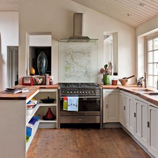 kitchen area with wooden floor and wooden counter with white wall