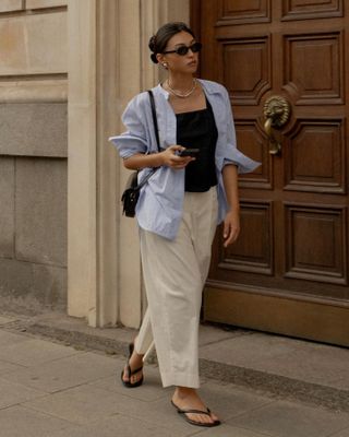 Sophisticated Fashion Trends: @michellelin.lin wears a blue linen shirt, black vest and beige trousers