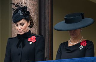 Kate Middleton and Duchess Sophie wearing black coats and hats looking down solemnly on Remembrance Day