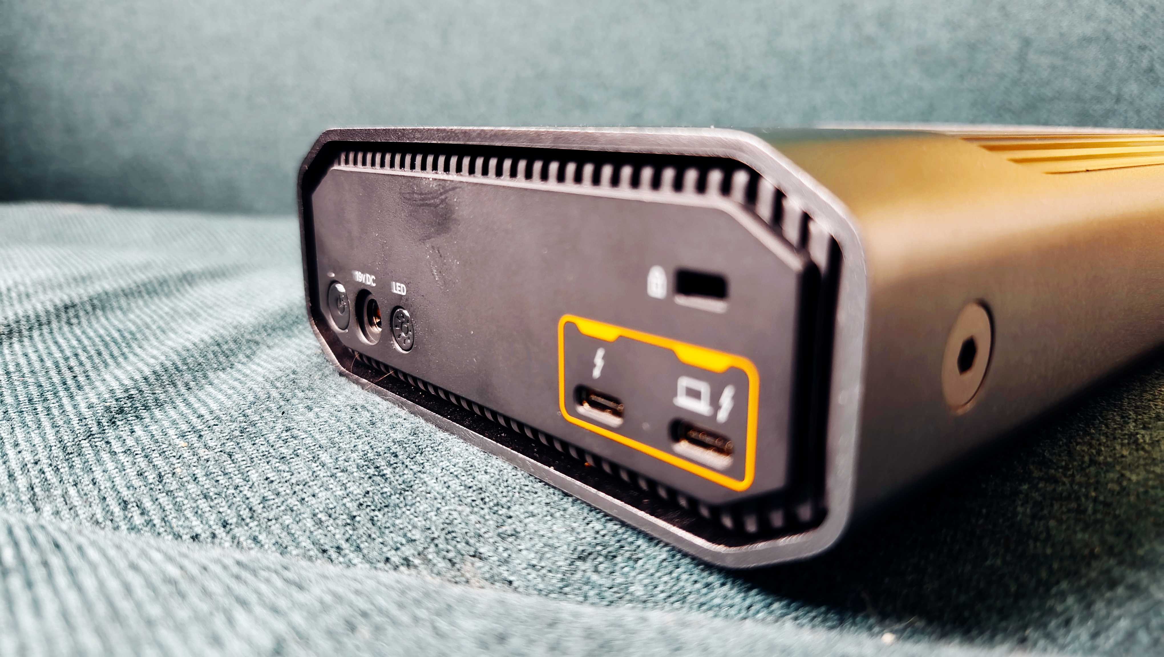 A grey and black SanDisk G-Drive sitting on a green sofa