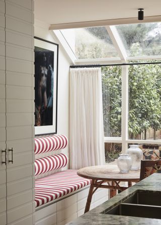 Dining nook with windows and striped bench