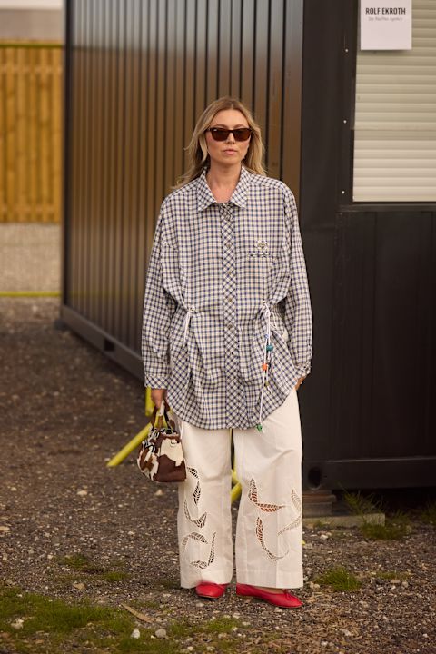 woman wearing a gingham shirt and a pair of white pants and red flats