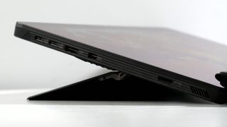 Asus ROG Flow Z13 (2025) with its kickstand extended, highlighting the ports on the left side, including two USB Type-C, an HDMI, microSD, and power jack.