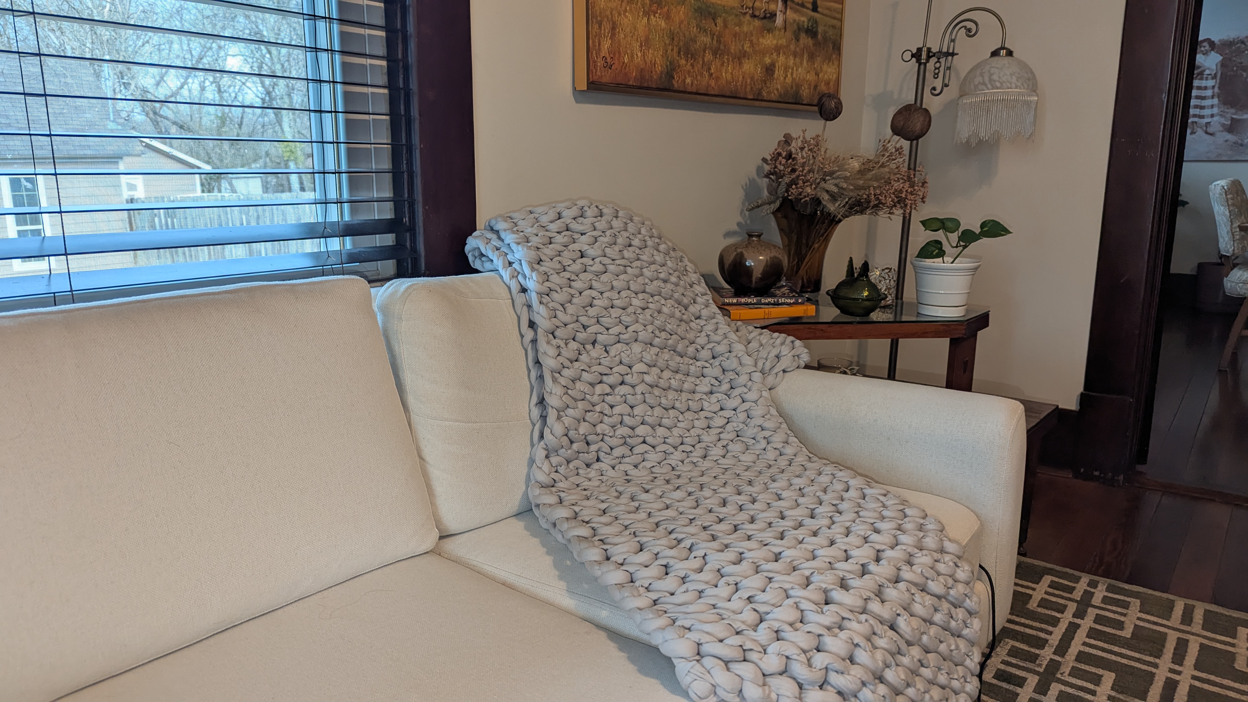 Grey Bearaby weighted blanket draped in the couch