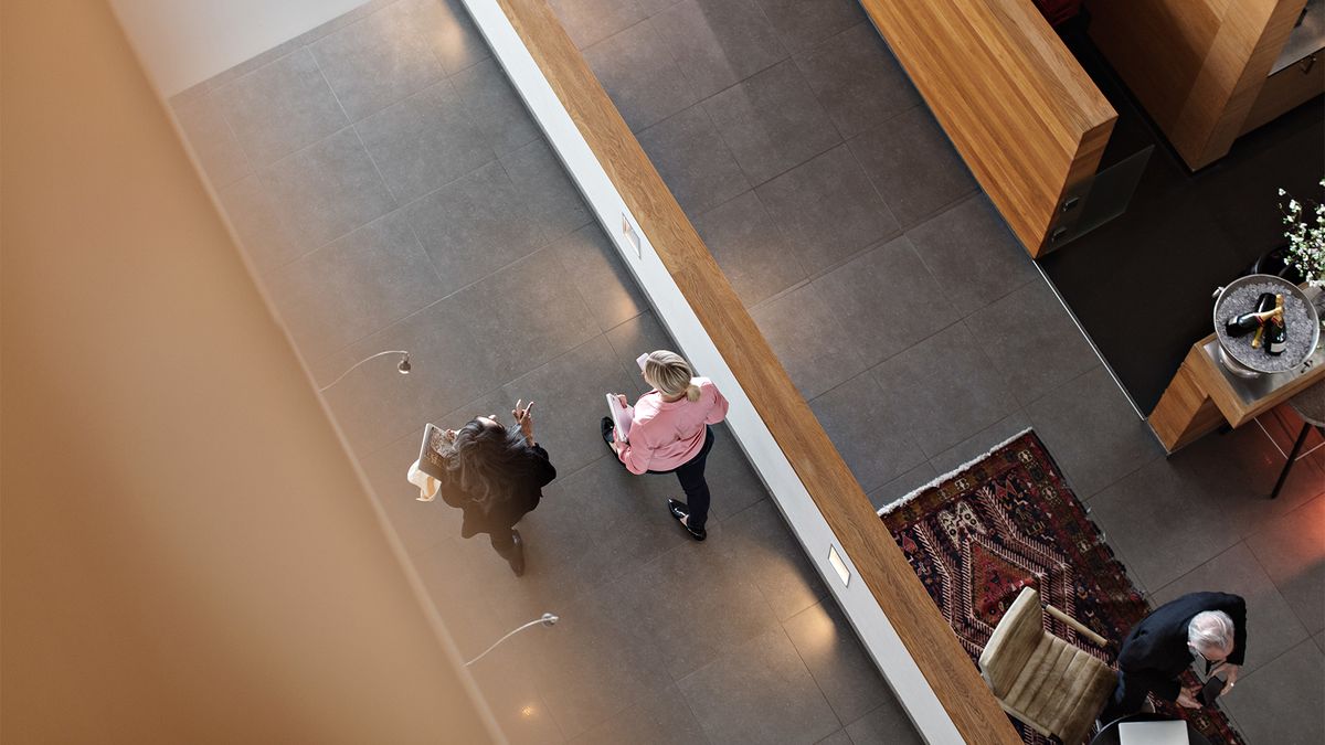 Return to office concept image showing workers talking while in an open plan office space. 