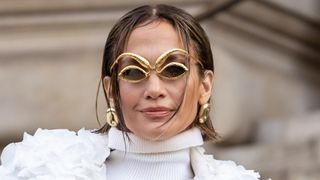 Jennifer Lopez pictured with a wet-look bob and wearing gold, angular sunglasses whilst attending the Schiaparelli Haute Couture Spring/Summer 2024 show as part of Paris Fashion Week on January 22, 2024 in Paris, France