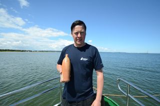 Tomasz Bednarz, an underwater archeologist from the National Maritime Museum in Gdańsk, is shown here holding the Selters vessel.