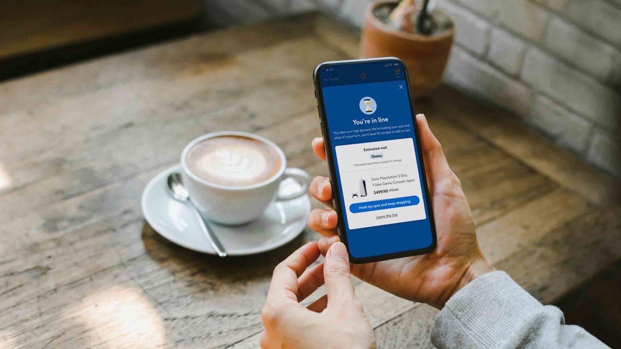 Shopper holds mobile showing Walmart virtual waiting line