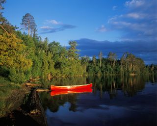 A Red Canoe floats on Lake Temagami, Ontario, Canada.