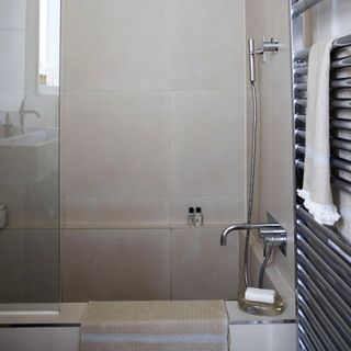 bathroom with white wall bathtub and silver towel rail