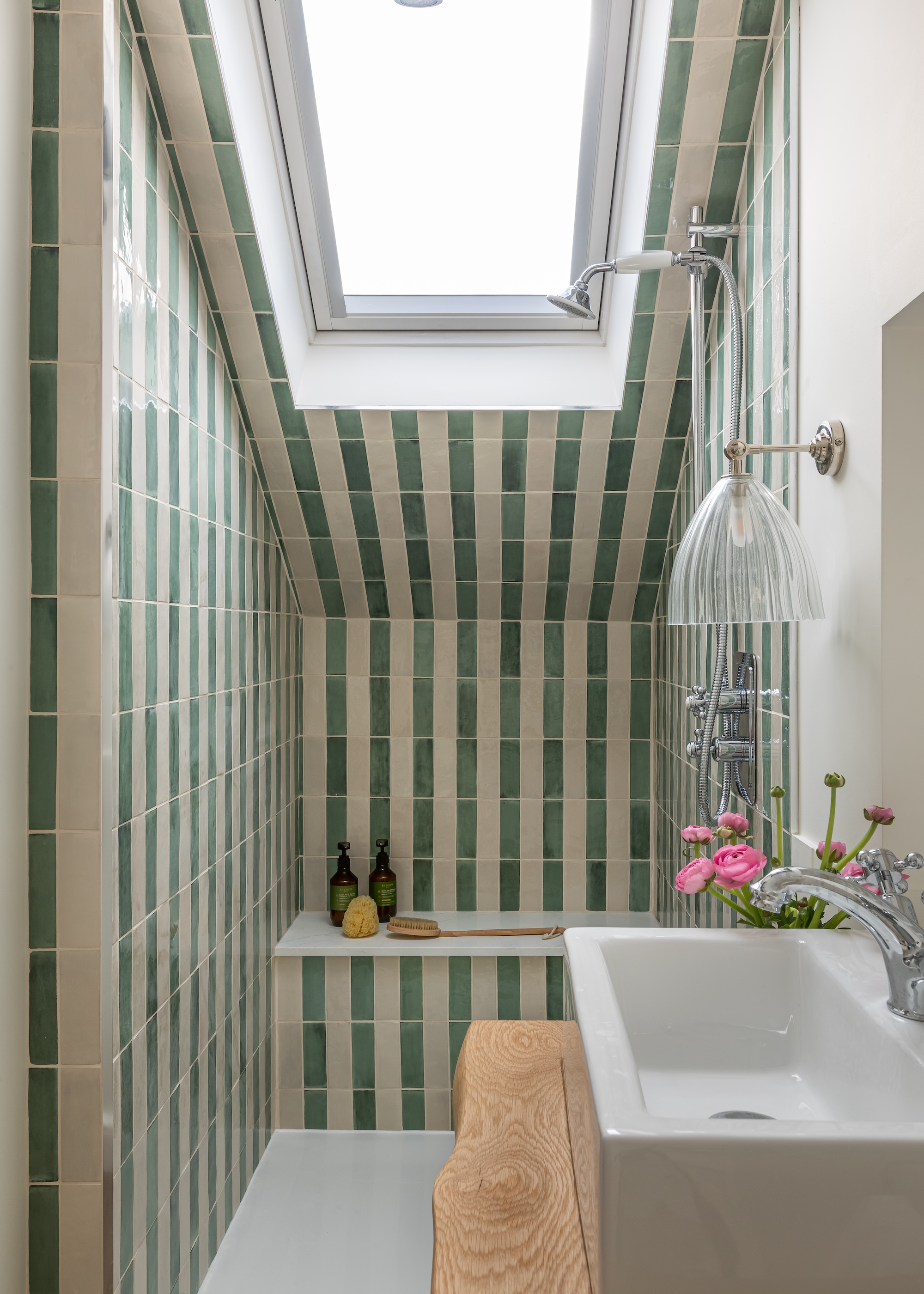 a walk in shower ensuite with tiles laid in a striped format
