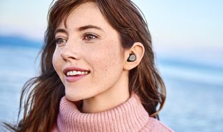 a woman wearing the jabra elite 7 pro true wireless earbuds