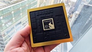 Qualcomm's new X2 Elite processor marketing prop being held by a window.