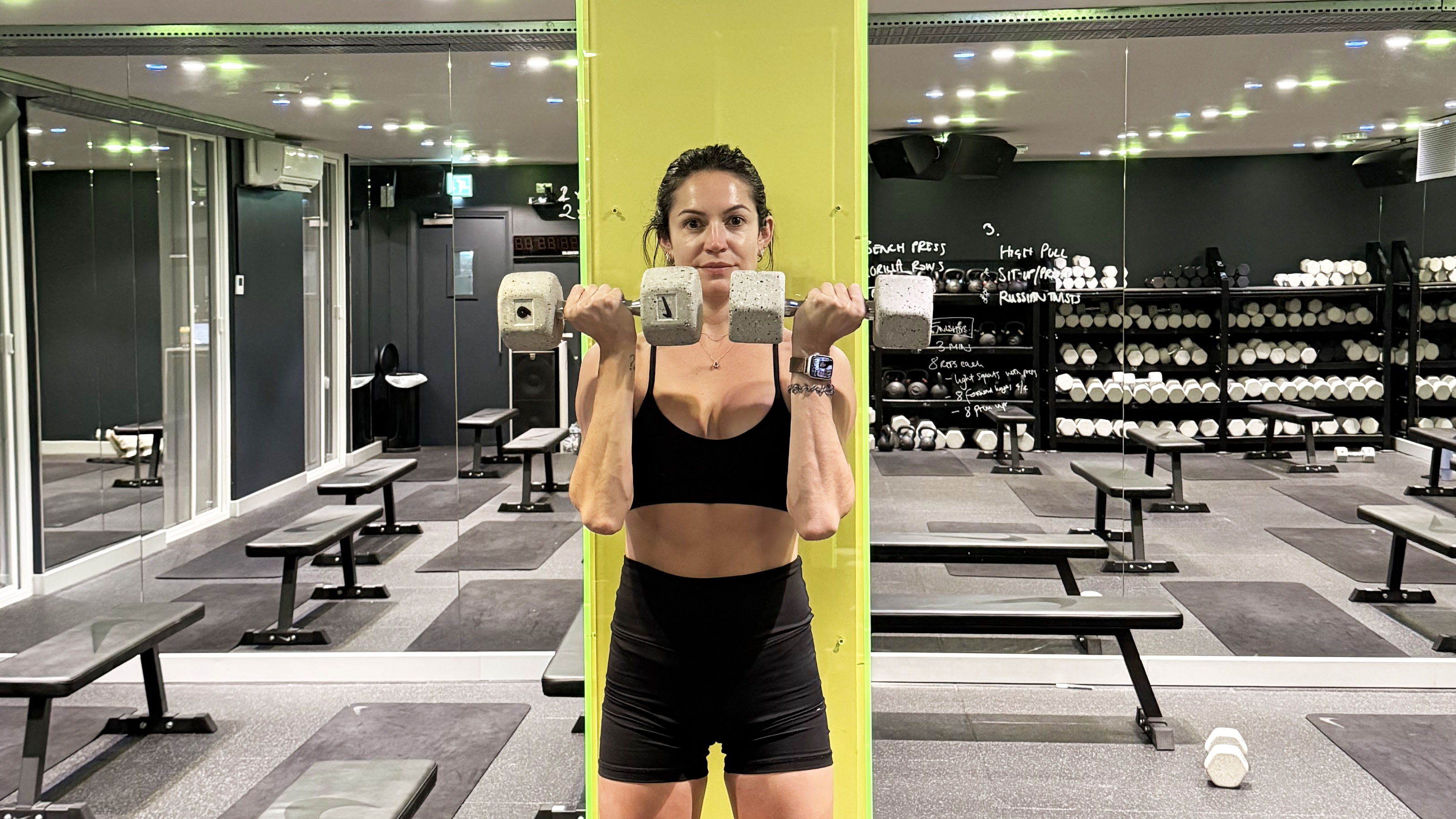 A photo of fitness writer Lucy Gornol is pressing Arnold Press