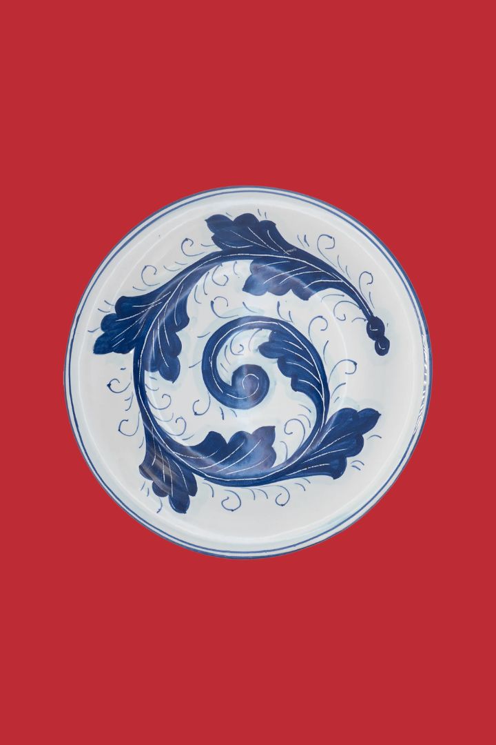 Fogli Bianchi E Blu Plate Antica Deruta 20.5 Cm against red background.