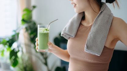 What to eat before a run: Image shows woman holding green smoothie