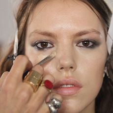 A model gets foundation applied backstage at the Houghton fashion show during MADE Fashion Week fall 2014 at Milk Studios on February 6, 2014 in New York City.