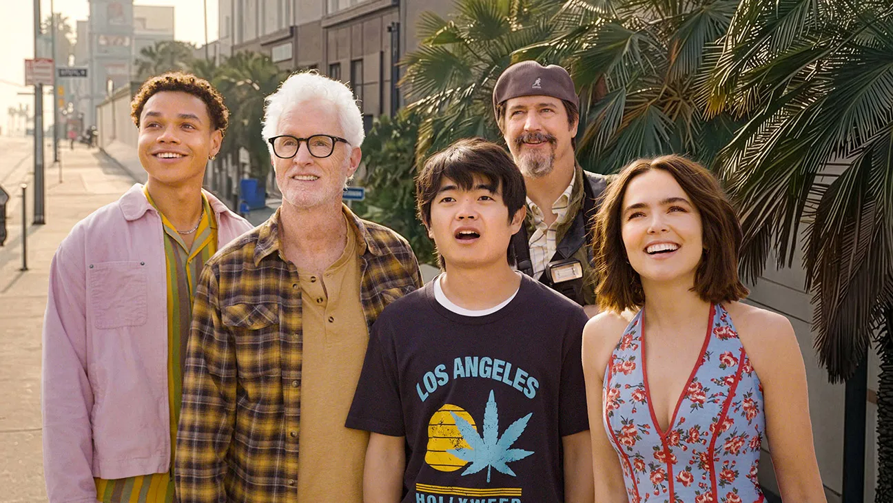 a group of people including john slattery jon ham and zoey deutch look off into the distance smiling in a still from gail daughtry and the celebrity sex pass
