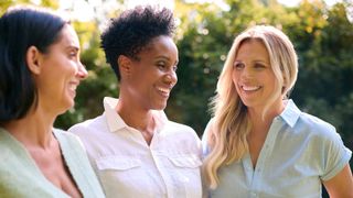 Three women standing together, laughing