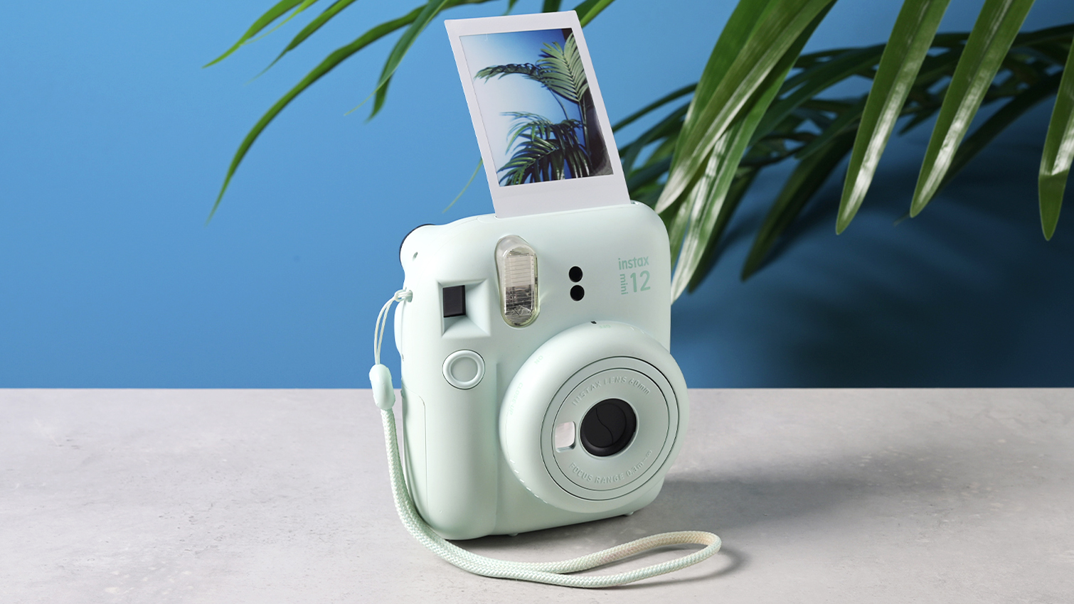 A mint green Fujifilm Instax mini 12 instant camera