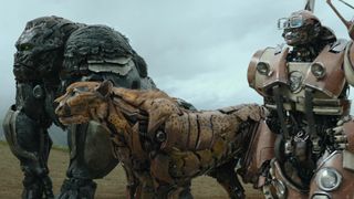Still from the movie Transformers: Rise of the Beasts. Standing side by side are the Transformers’ Optimus Primal (gorilla), Cheetor (Cheetah), and another Transformer in robot mode.