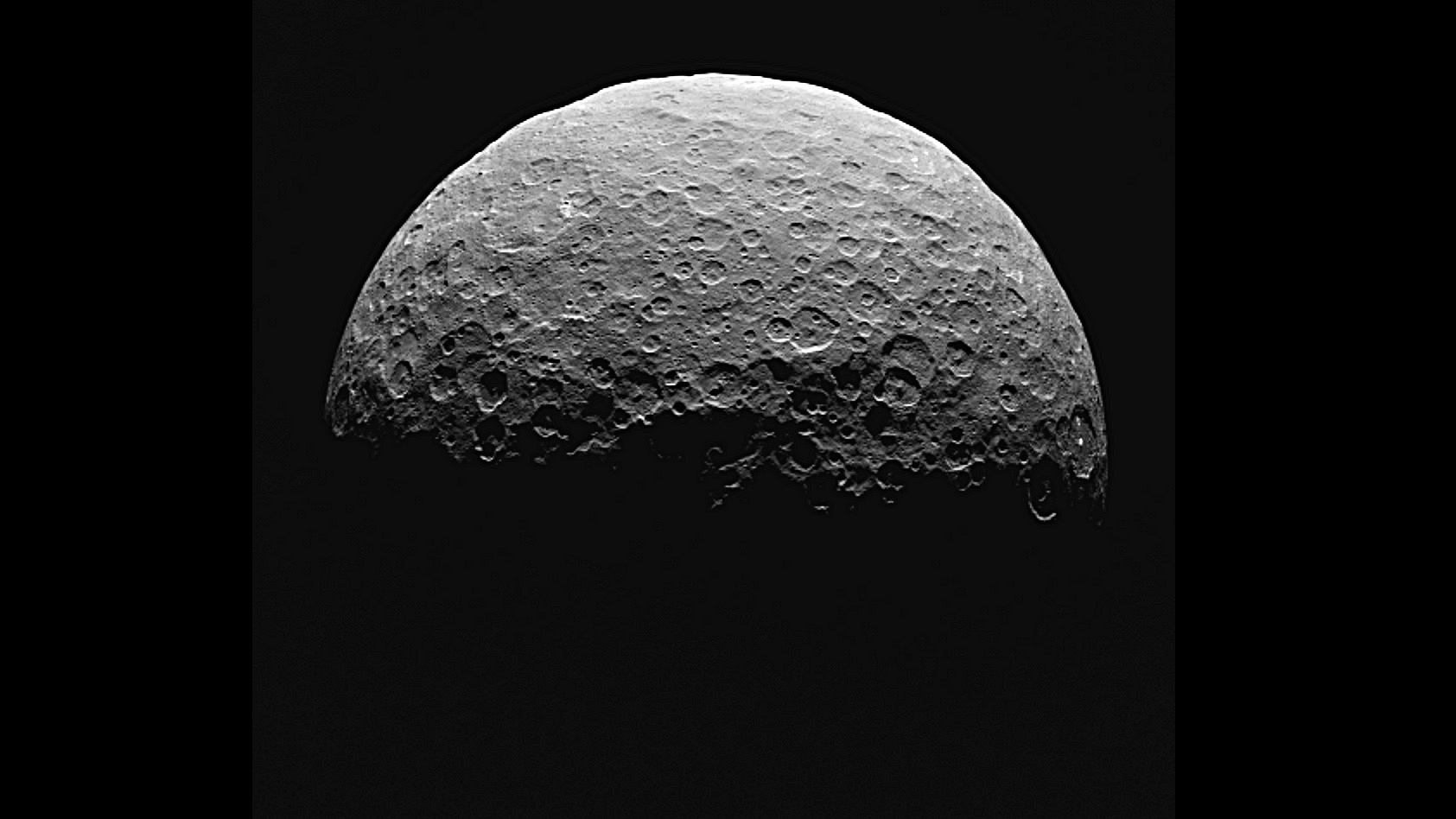 Half illuminated Ceres covered with craters.
