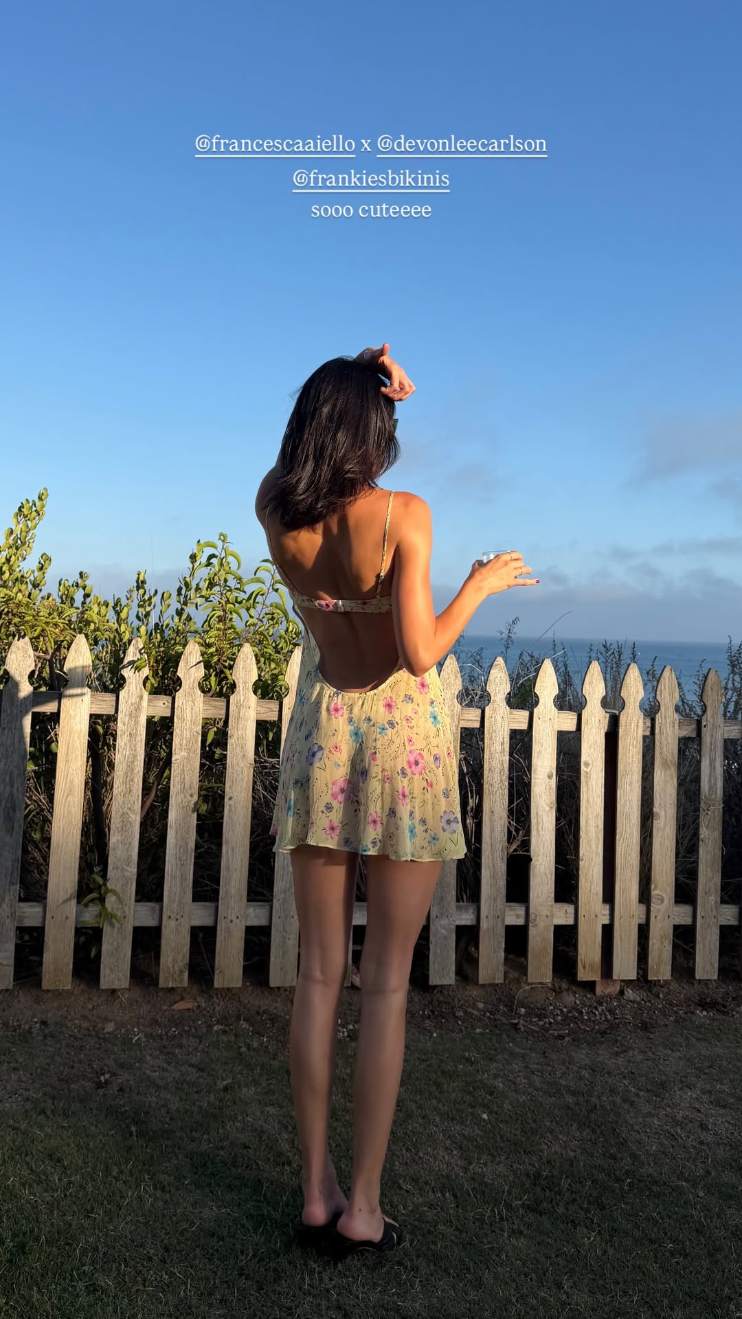 Kendall Jenner wears a butter yellow mini dress featuring pink and blue flowers from Devon Lee Carson x Frankies Bikinis