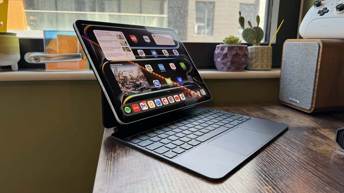 An Apple iPad Pro connected to a keyboard case and sitting on a wooden desk.