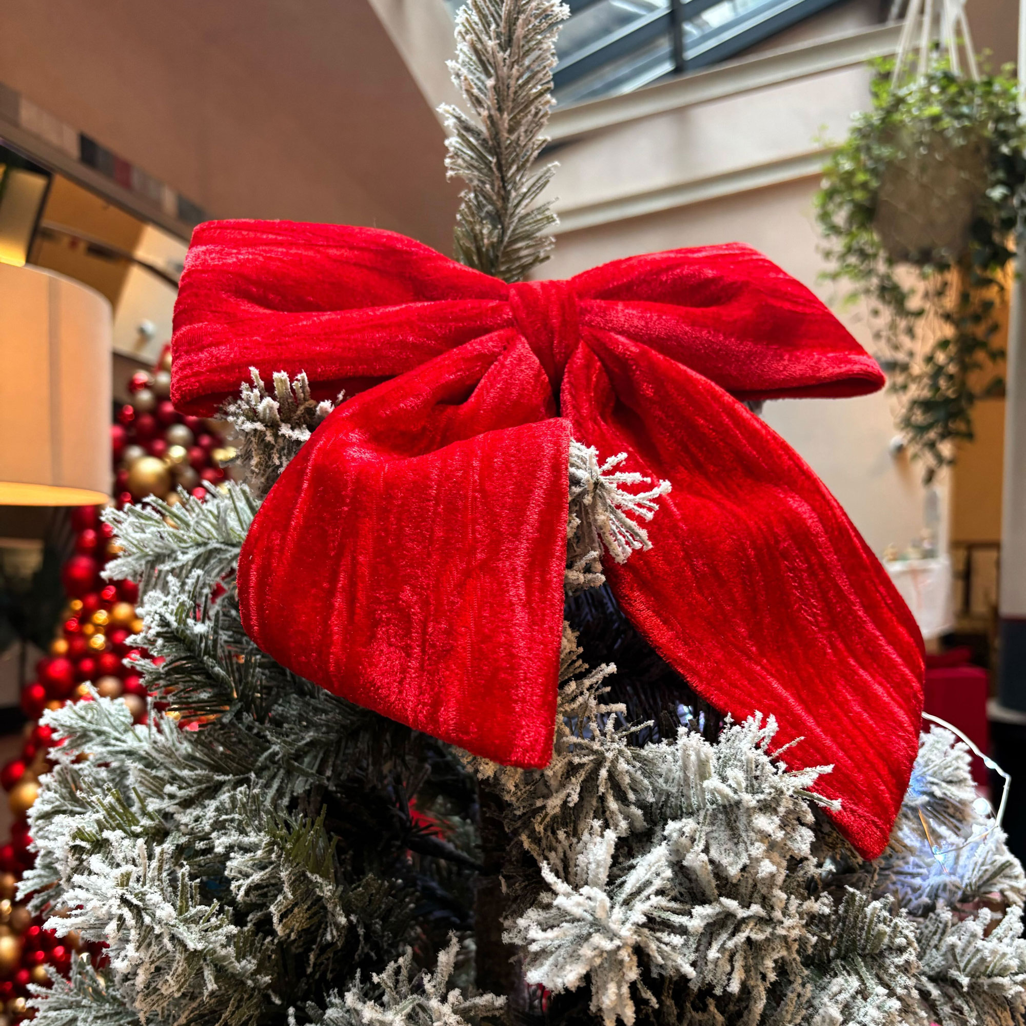 Snow covered faux tree with red ribbon