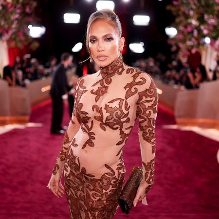 a latina woman poses for paparazzi at a red carpet event