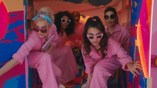 Barbie (Margot Robbie), Barbie (Alexandria Shipp), Allan (Michael Cera), Sasha (Ariana Greenblatt) and Gloria (America Ferrera in pink jumpsuits getting out of the van in the Barbie Movie.