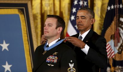 Barack Obama (R) awards the Medal of Honor to U.S. Navy Senior Chief Special Warfare Operator Edward Byers during a ceremony at the White House in Washington February 29, 2016.